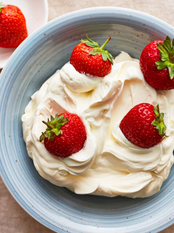 A blue plate with mascarpone cheese and strawberries.