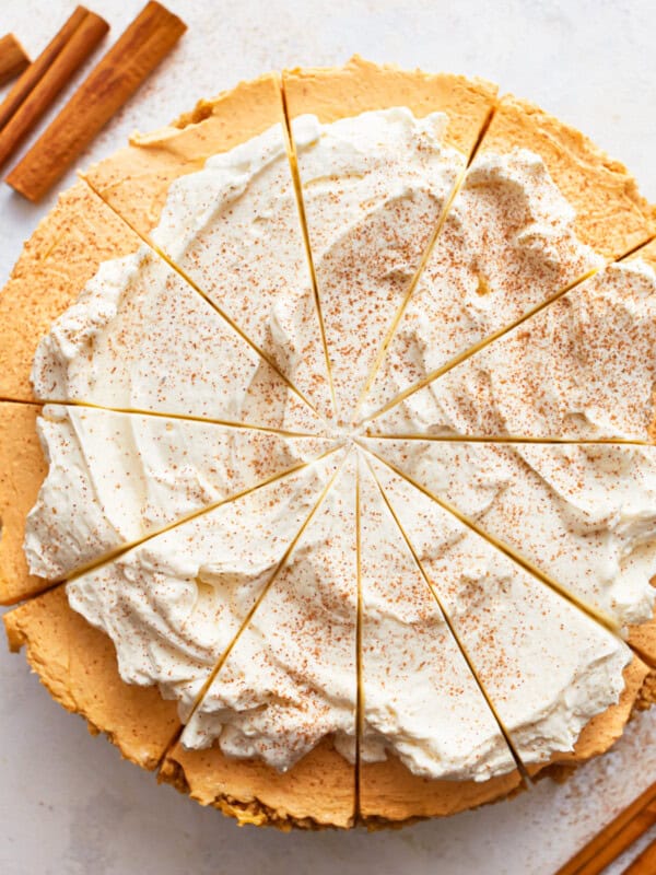 A no bake pumpkin pie cheesecake with whipped cream and cinnamon.