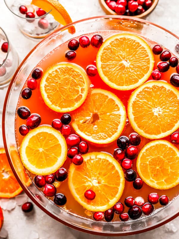 A bowl filled with oranges and cranberries.