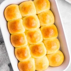 overhead view of 15 dinner rolls in a white baking dish.