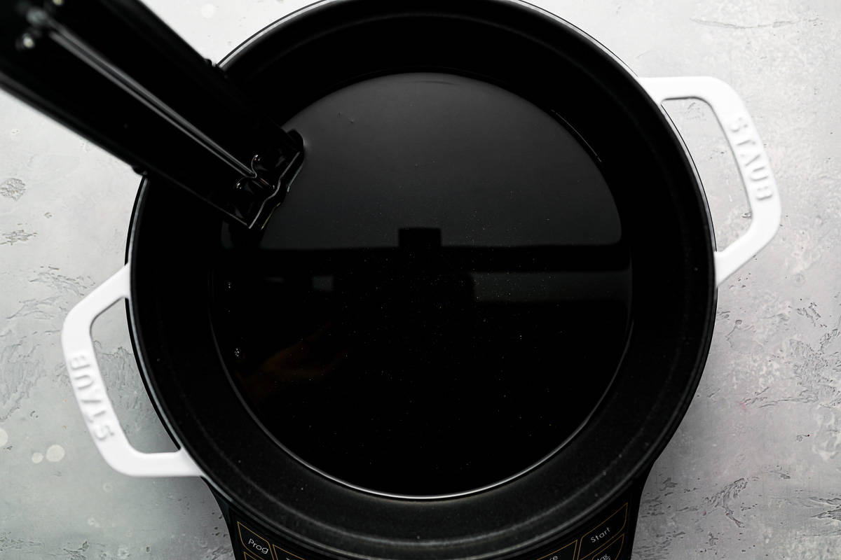 A black pot with a lid on top of it.