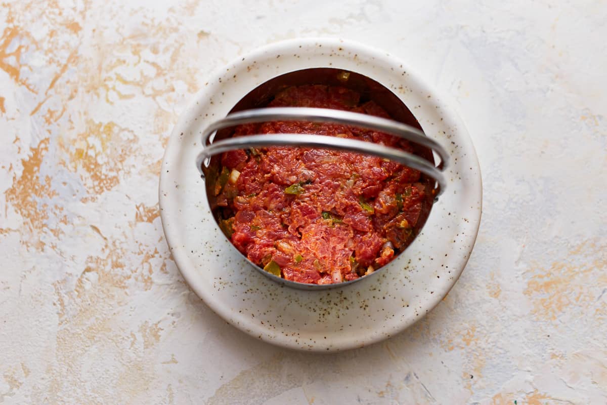 A bowl of meat on a white plate.