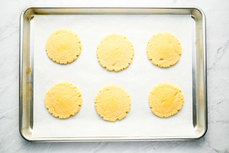 Cookies on a baking sheet on a marble countertop.