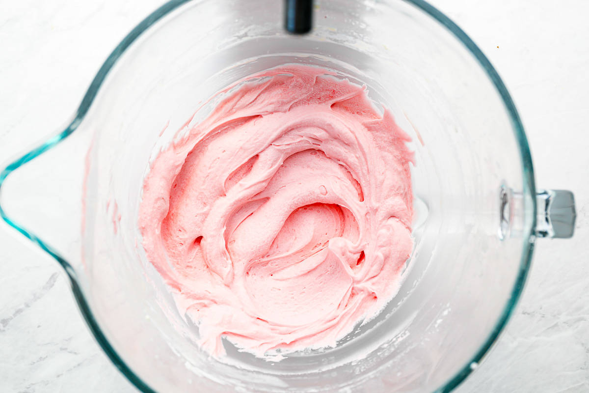 Pink icing in a glass bowl.
