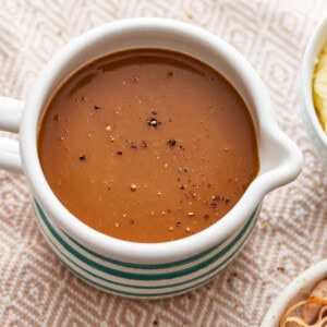 A bowl of gravy on a table.