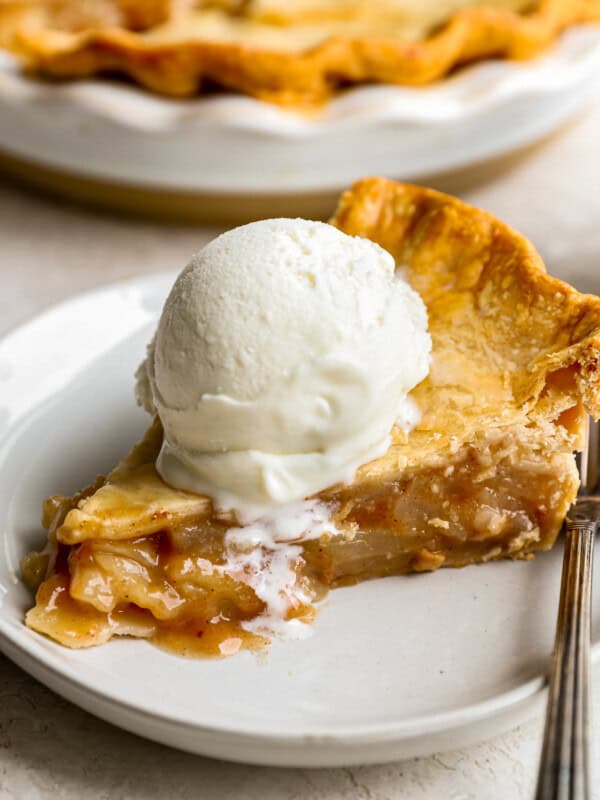 A slice of apple pie with ice cream on a plate.