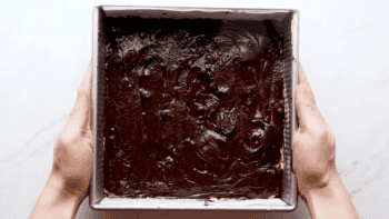unbaked layered pumpkin brownies in a square pan.