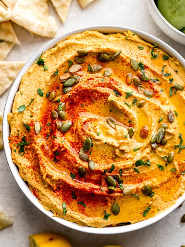 A bowl of hummus with pita chips.