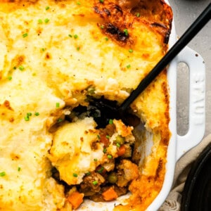 A dish of shepherd's pie with a spoon in it.