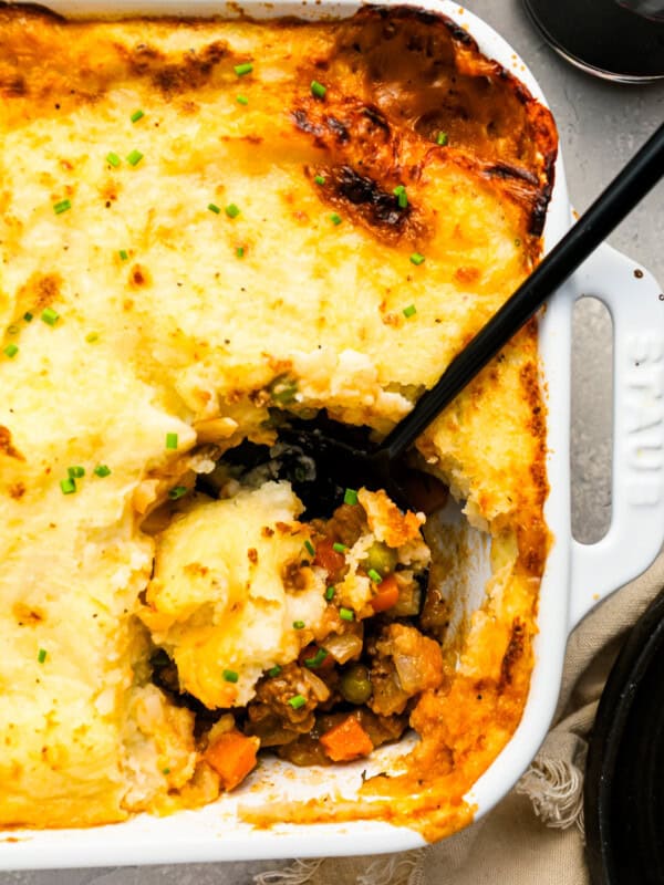 A dish of shepherd's pie with a spoon in it.