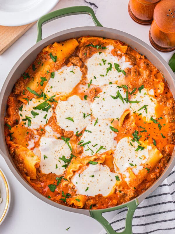 Lasagna in a pan with parmesan cheese on top.