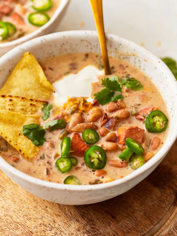 Two bowls of chili with tortilla chips and jalapenos.