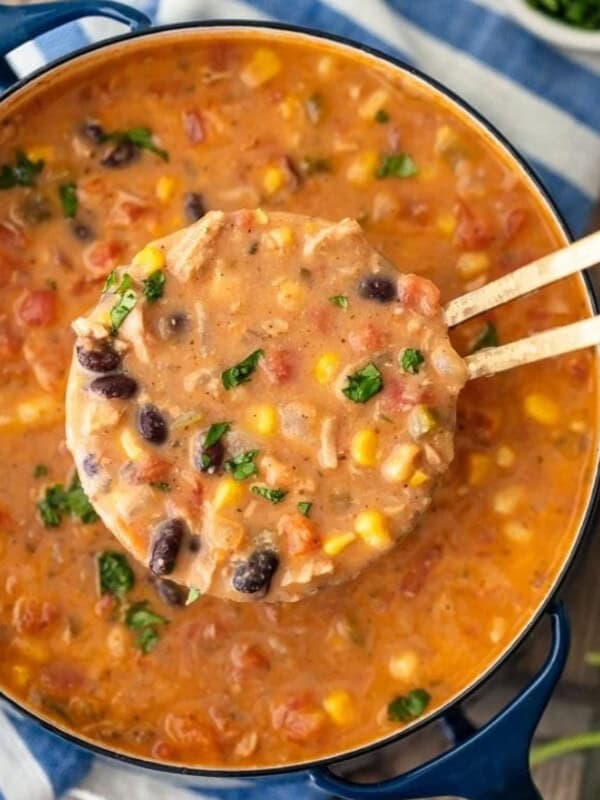 Creamy Mexican chicken tortilla soup in a pot with wooden spoons.