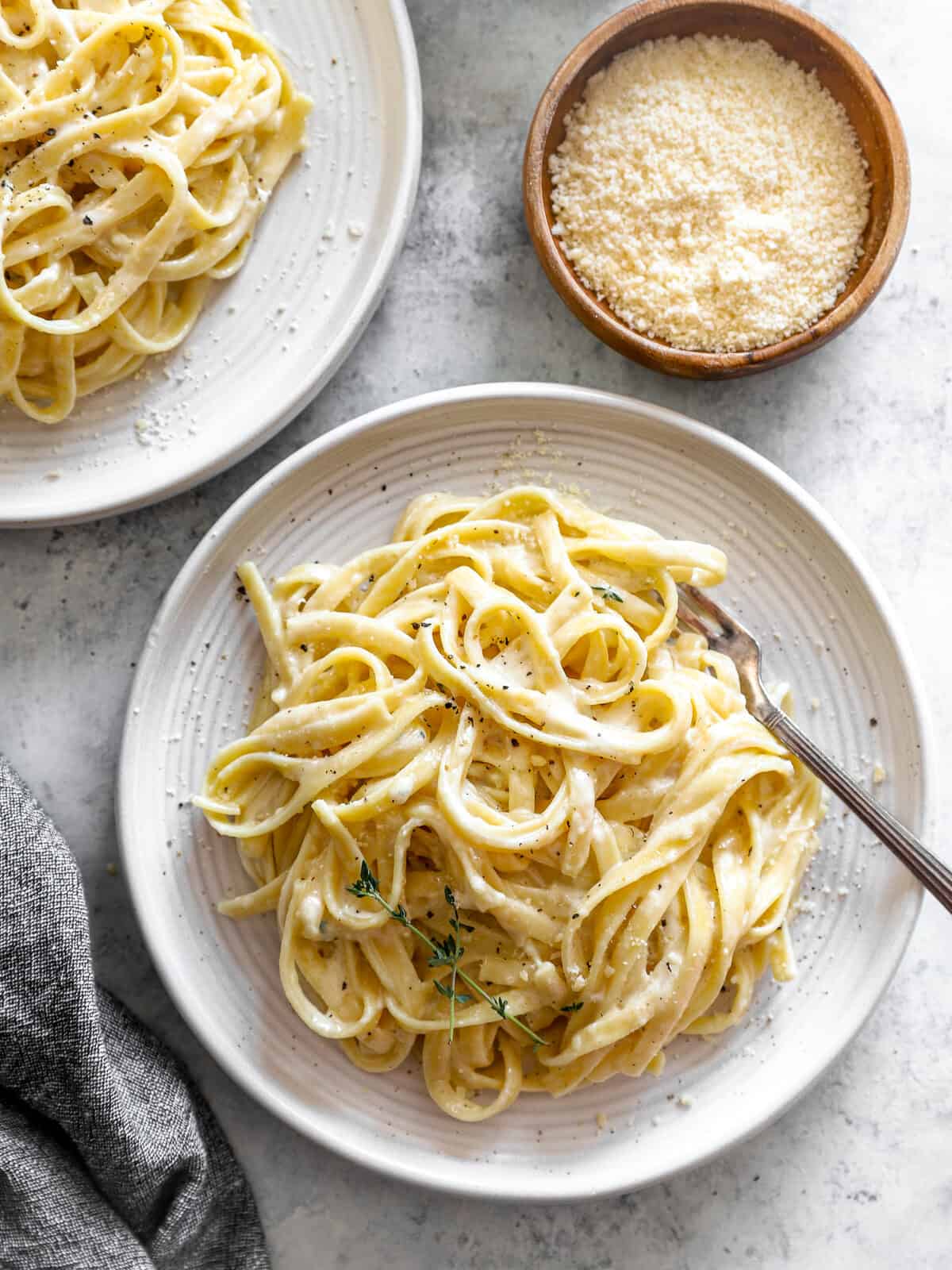 overhead view of a serving of fettuccini alfredo on a white plate with a fork.