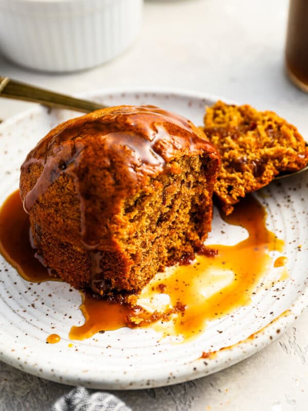 partially eaten sticky toffee pudding on a white plate.