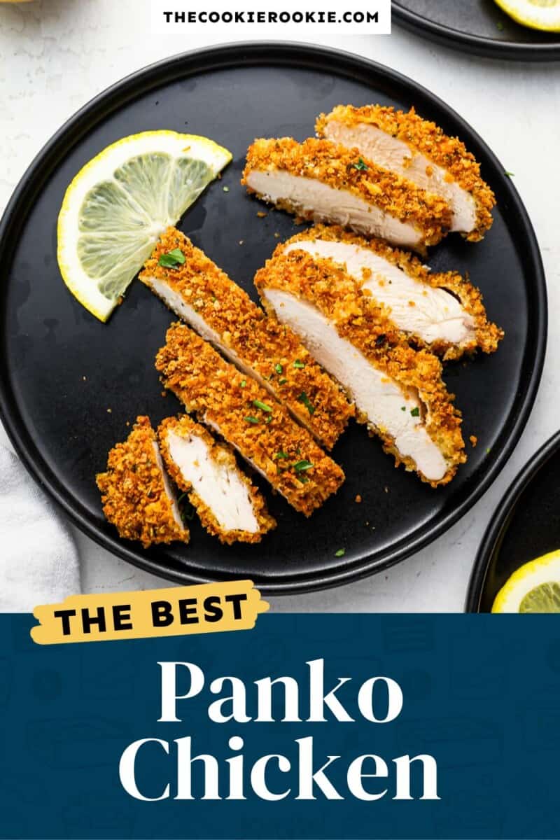 Panko chicken on a black plate with lemon slices.