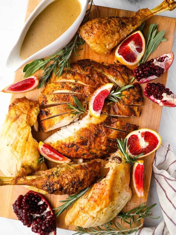 roasted turkey with pomegranate sauce on a cutting board.