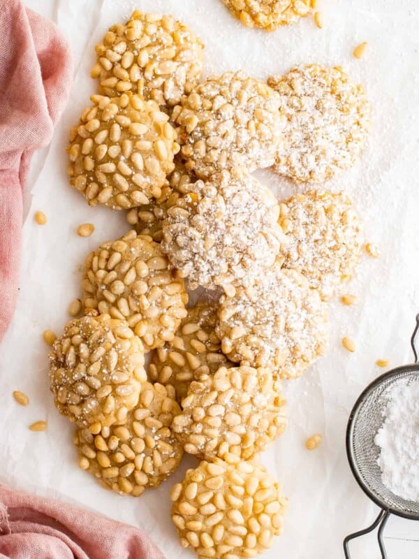 overhead image of pignoli cookies with a dusting of powdered sugar