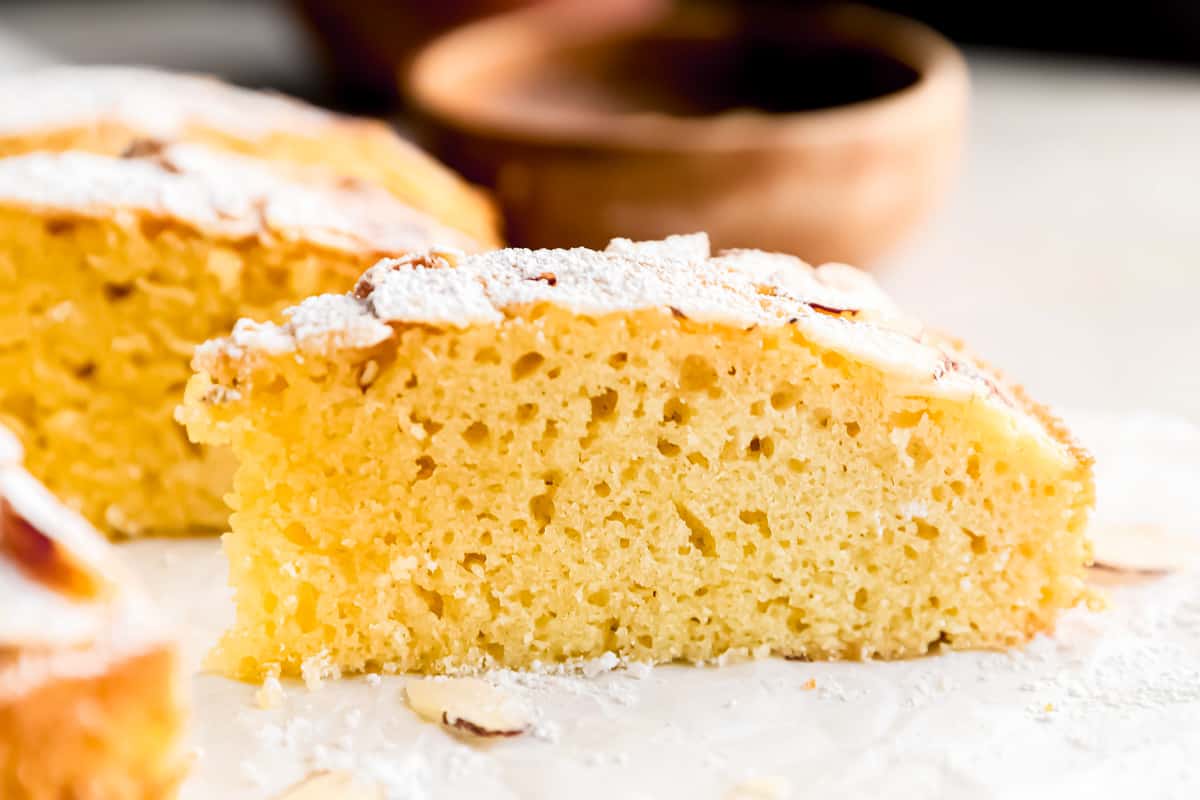 A slice of almond cake coated with powdered sugar.