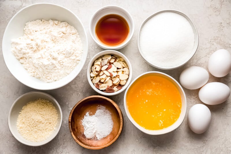 A bowl of ingredients for an almond cake, including flour, eggs and sugar.