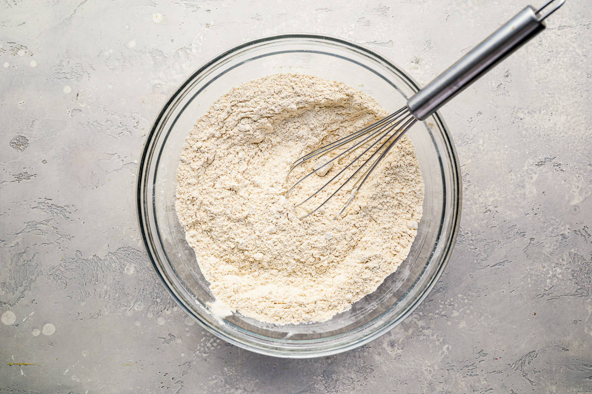 flour mixture in a glass mixing bowl, with a whisk.