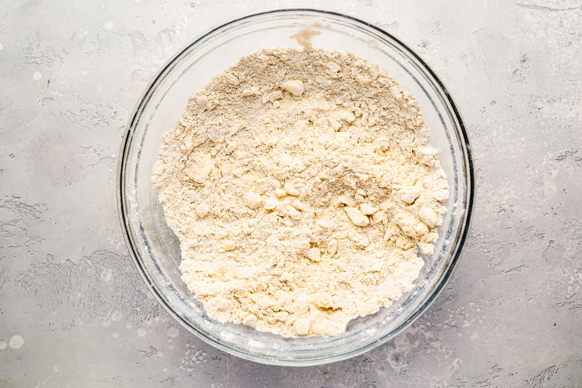 crumbly flour mixture in a glass mixing bowl.