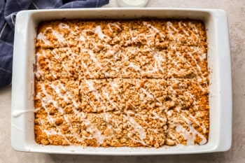 Oatmeal raisin bars in a white baking dish with icing.