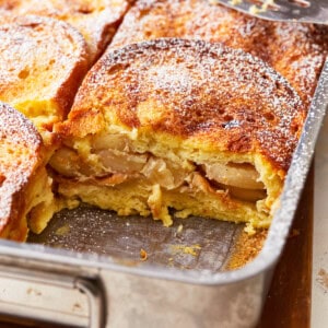 An apple french toast casserole in a pan with a fork.