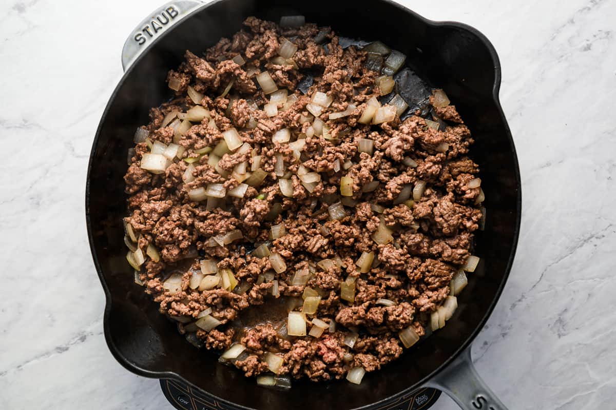 Ground beef and onion mixture cooking in a skillet.