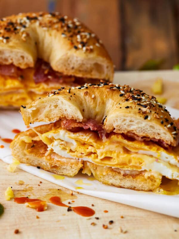 A bagel breakfast sandwich with eggs and bacon on it.