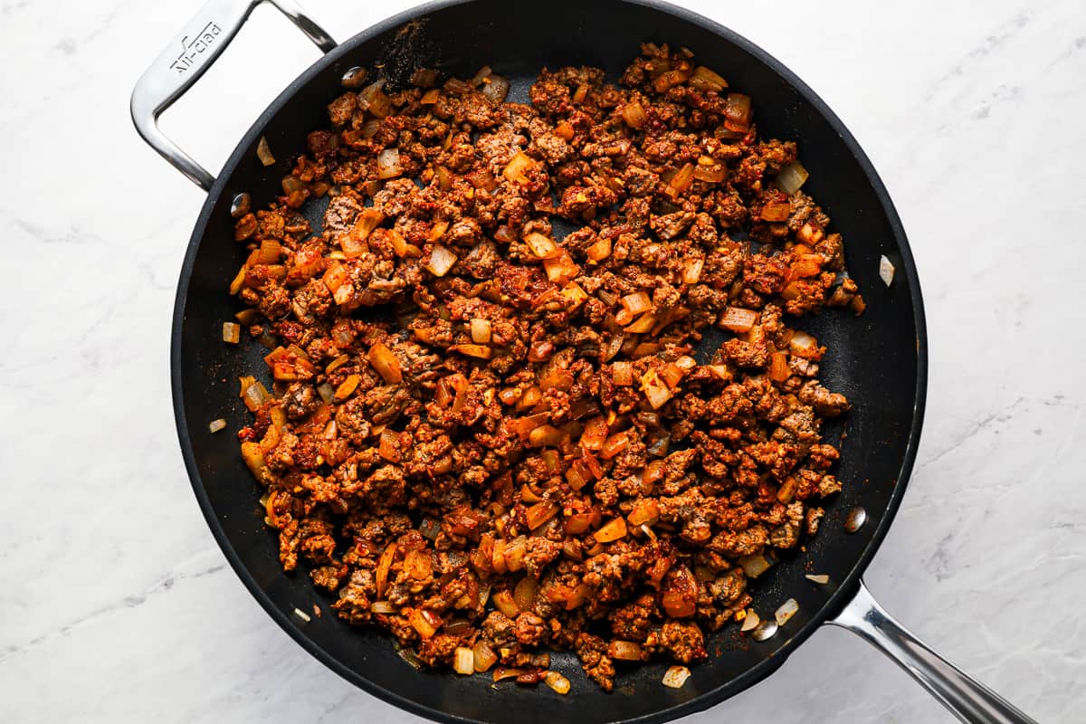 Seasoned ground beef mixture cooking in a skillet.