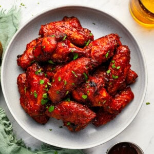 Plate of bbq chicken wings with a glass of beer.