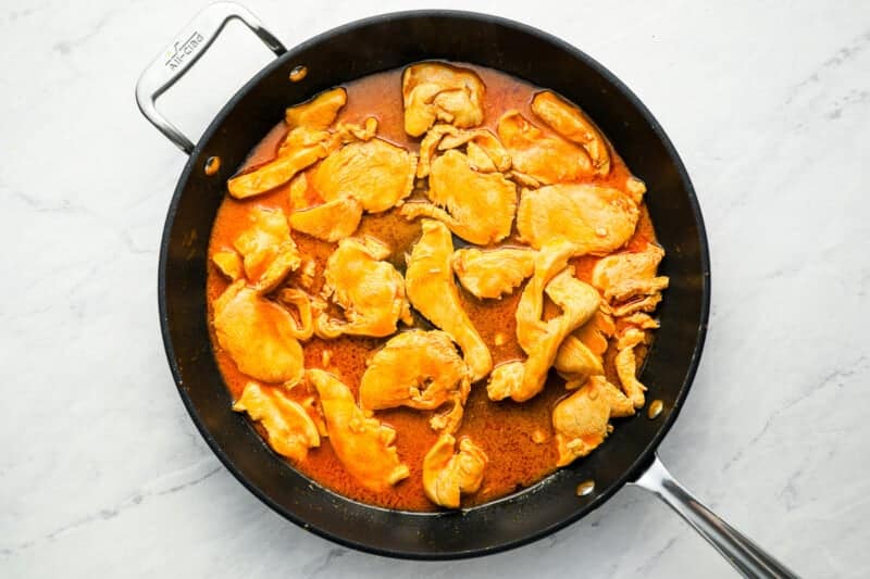 Buffalo chicken curry in a pan with a spoon.