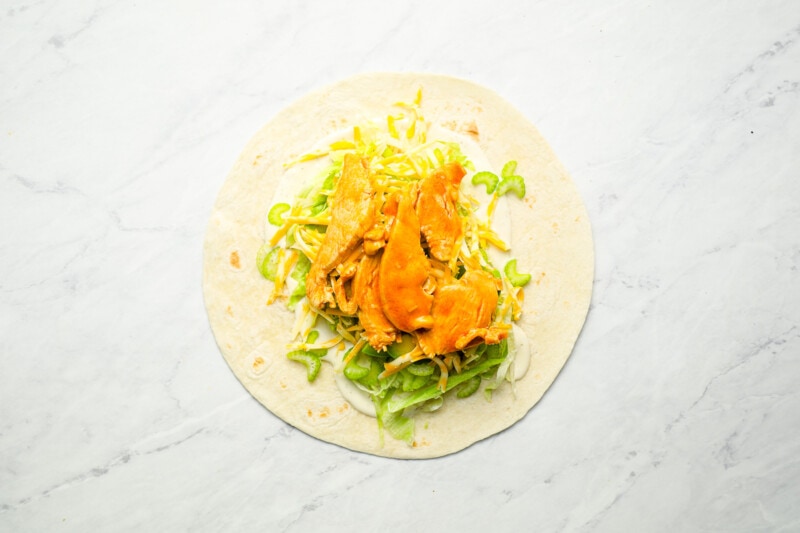 A buffalo chicken wrap on a white surface.