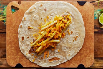 A California burrito on a wooden cutting board.