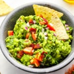 blt guacamole in a bowl with tortilla chips.