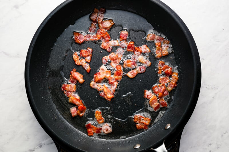 cooked bacon bits in a cast iron pan.