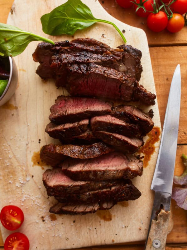 overhead view of sliced ribeye steak on a cutting board.