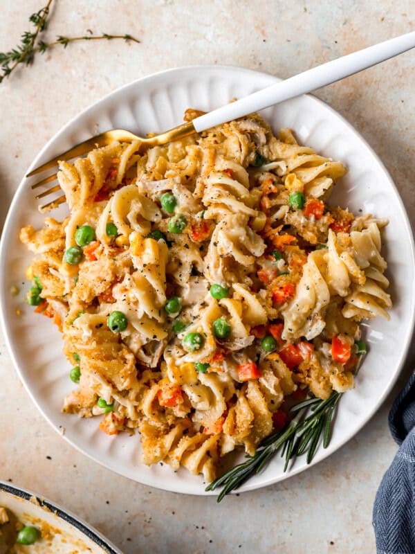 overhead view of a serving of chicken noodle casserole on a white plate with a fork.