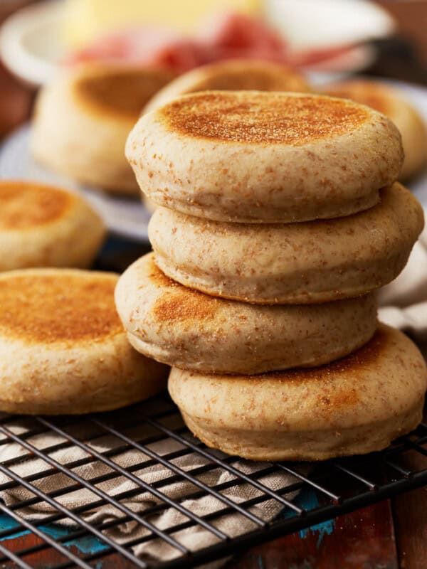 a stack of 4 english muffins on a wire rack.