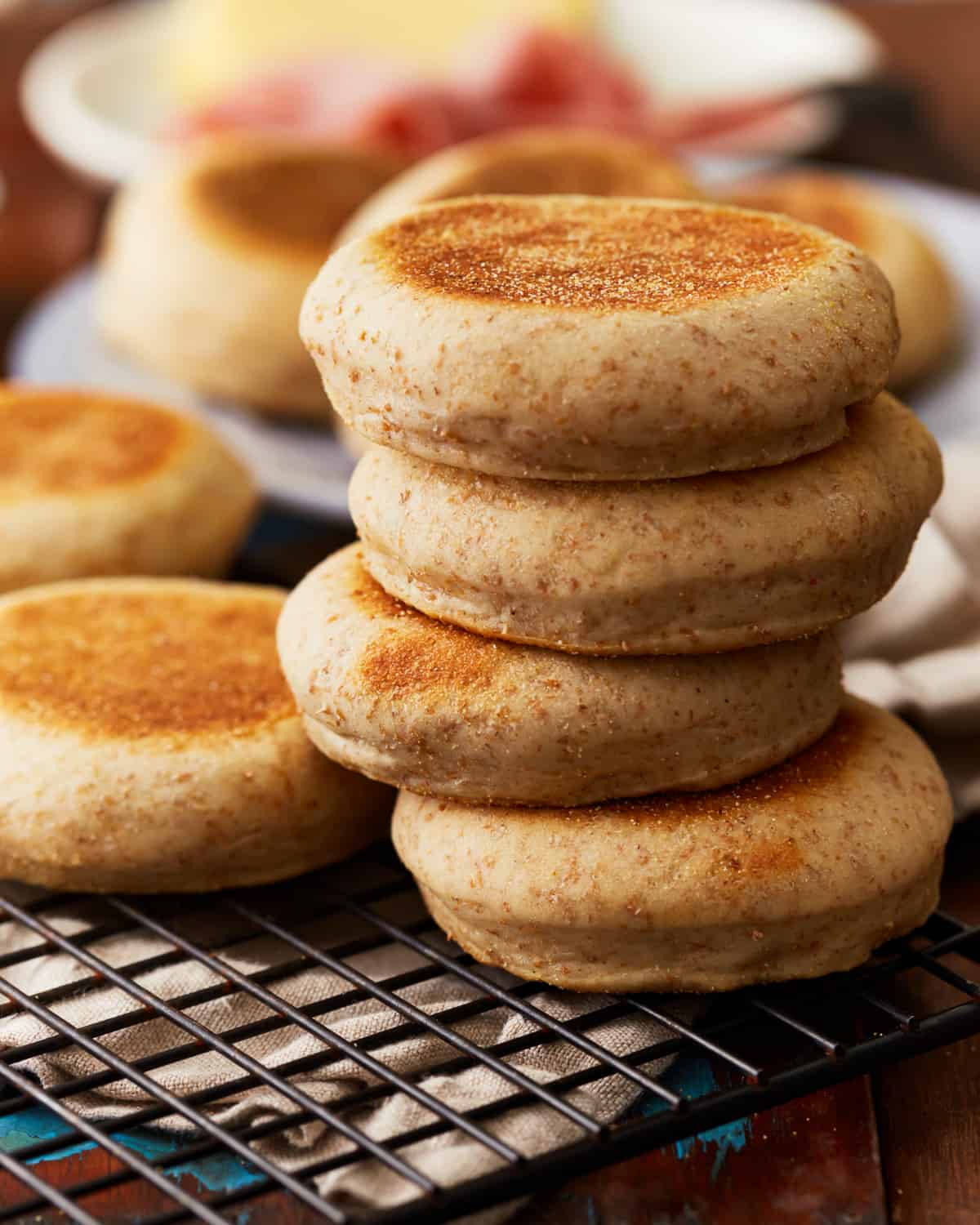 a stack of 4 english muffins on a wire rack.