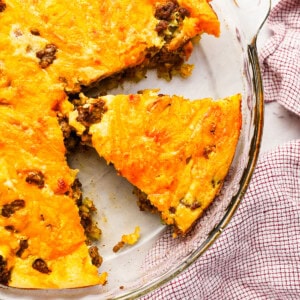 a separated slice of cheeseburger pie in a pie plate.