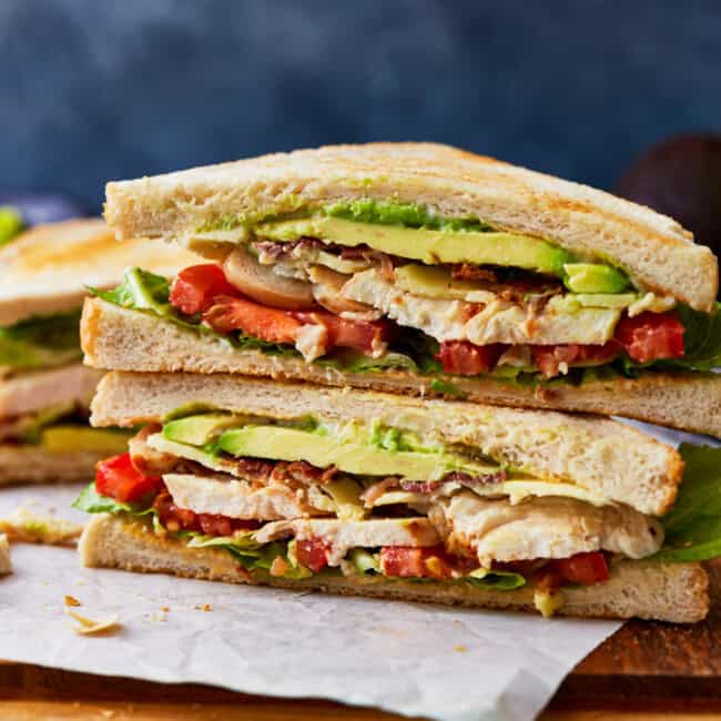 side view of a halved and stacked chicken club sandwich.