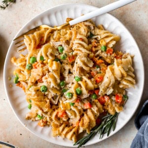 overhead view of a serving of chicken noodle casserole on a white plate with a fork.