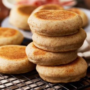 a stack of 4 english muffins on a wire rack.