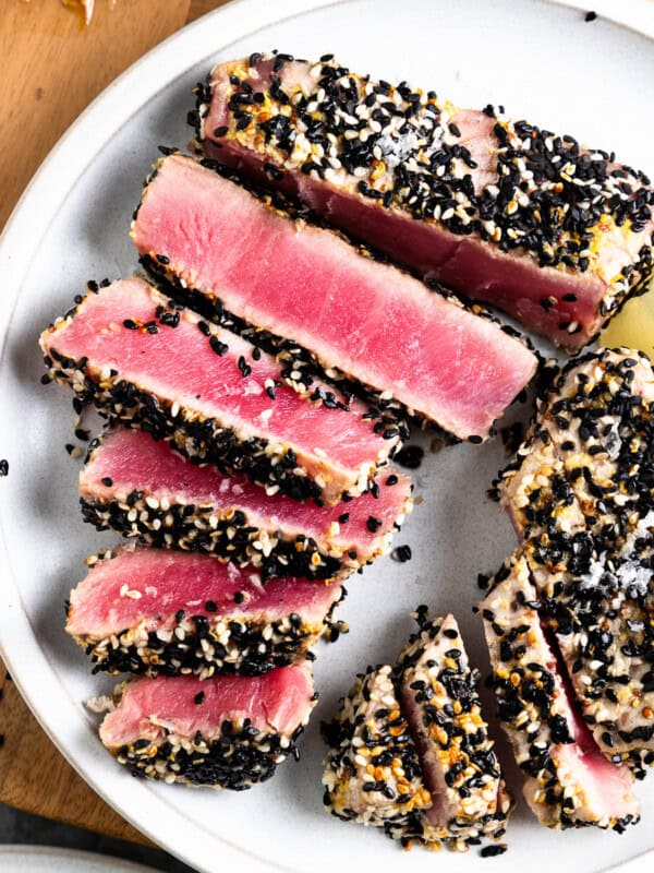 a plate of seared ahi tuna, covered in sesame seeds.