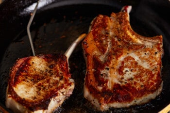 seared bone in pork chops in a cast iron pan.