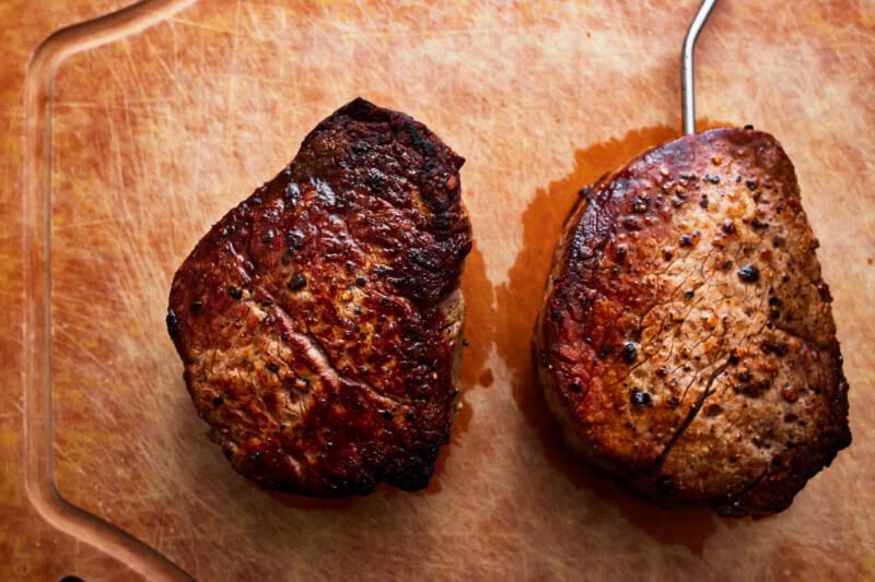 2 filets on a cutting board, one with a meat probe sticking out.