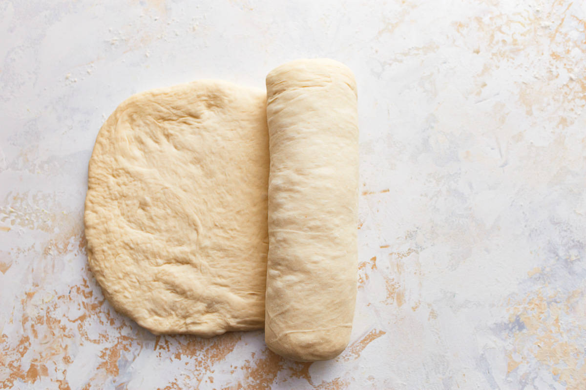 rolling up bread dough into a loaf.