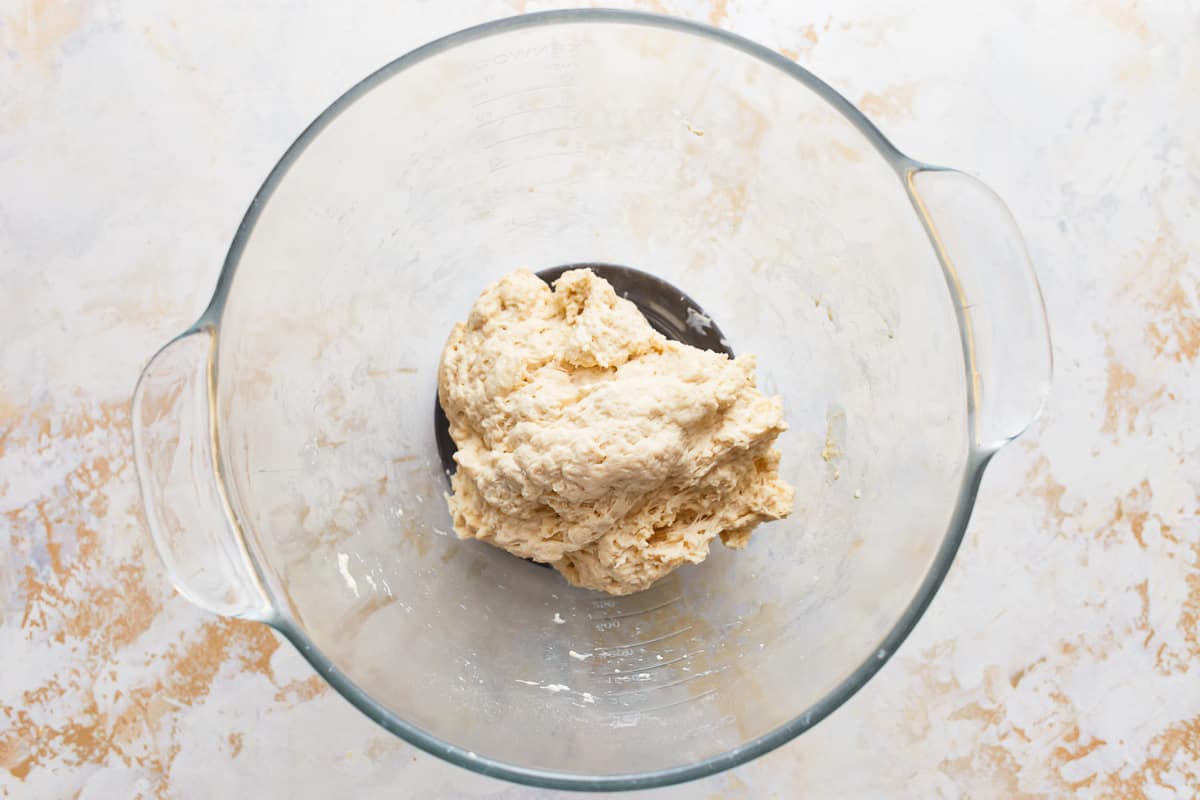 bread dough in a glass bowl before kneading.